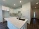 Modern kitchen featuring white cabinetry, granite countertops, and a central island with a sink at 137 W G H Washington St, Apopka, FL 32703