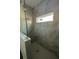 Modern shower with gray marble-look tile surround, glass door, and window at 137 W G H Washington St, Apopka, FL 32703