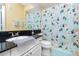 Well-lit bathroom featuring a shower with patterned curtains and a white sink with black countertops at 14316 Fredricksburg Dr # 507, Orlando, FL 32837