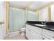 Well-lit bathroom with a shower and tub combination, white sink, black countertop, and tile flooring at 14316 Fredricksburg Dr # 507, Orlando, FL 32837