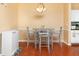 Bright dining area featuring wood floors, modern lighting, and a glass-topped table at 14316 Fredricksburg Dr # 507, Orlando, FL 32837