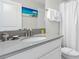 Clean and bright bathroom with a white vanity, a large mirror, and neutral-toned finishes throughout at 1551 Flange Dr, Davenport, FL 33896
