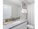 Bathroom featuring a grey quartz countertop vanity with a large mirror and a shower behind a curtain at 1551 Flange Dr, Davenport, FL 33896