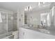 Modern bathroom featuring double sinks, a large mirror, and a glass-enclosed shower with decorative purple art at 1551 Flange Dr, Davenport, FL 33896