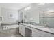Bright bathroom featuring dual sinks, white cabinetry, soaking tub, and a glass-enclosed shower at 1551 Flange Dr, Davenport, FL 33896