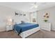Bright bedroom with a white bedframe, blue comforter, three hanging artwork pieces, and white curtains at 1551 Flange Dr, Davenport, FL 33896