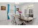 Elegant dining room with large wood table, upholstered chairs, pendant lighting, and bright curtains at 1551 Flange Dr, Davenport, FL 33896