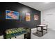 Spacious game room featuring a foosball table, an air hockey table, and decorative art on a dark wall at 1551 Flange Dr, Davenport, FL 33896
