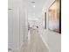 Bright hallway with neutral tile flooring leading to various rooms of the home at 1551 Flange Dr, Davenport, FL 33896