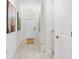 Hallway with tile flooring, artwork, and a view of the front door and staircase at 1551 Flange Dr, Davenport, FL 33896