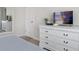 Well-organized main bedroom featuring a white dresser, mirror, and a flat screen television for relaxation at 1551 Flange Dr, Davenport, FL 33896