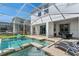 Screened-in pool area with a spa, lounge chairs, and outdoor dining set, perfect for relaxation and entertaining at 1551 Flange Dr, Davenport, FL 33896