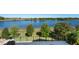 Expansive backyard featuring a pool, lake view, and meticulously maintained landscaping at 15681 Panther Lake Dr, Winter Garden, FL 34787