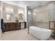 This primary bathroom features a modern soaking tub, glass enclosed shower and dual sinks with attractive vanities at 15681 Panther Lake Dr, Winter Garden, FL 34787