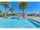 Resort-style community pool featuring palm trees and lounge seating for a relaxing experience at 15681 Panther Lake Dr, Winter Garden, FL 34787