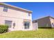 A sunny backyard with a grassy lawn, privacy fence, and a sliding glass door entrance at 16241 Old Ash Loop, Orlando, FL 32828