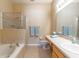 Clean bathroom with a soaking tub, a glass-enclosed shower, and a large mirror above the vanity at 16241 Old Ash Loop, Orlando, FL 32828