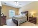 Cozy bedroom with a wooden bed frame, neutral-colored walls, and a window providing natural light at 16241 Old Ash Loop, Orlando, FL 32828