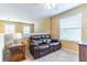 Cozy bonus room featuring a plush leather loveseat and ample natural light at 16241 Old Ash Loop, Orlando, FL 32828