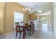Cozy dining area with a wooden table and chairs, chandelier lighting, and natural light at 16241 Old Ash Loop, Orlando, FL 32828