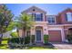 Close up of a charming two-story townhome with a colorful facade, lush landscaping, and front yard at 16241 Old Ash Loop, Orlando, FL 32828