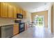 Well-lit kitchen with black appliances, wooden cabinets, and a view of the backyard through sliding glass doors at 16241 Old Ash Loop, Orlando, FL 32828