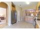 Modern kitchen with stainless steel refrigerator, wooden cabinets, tile flooring, and an arched doorway to another room at 16241 Old Ash Loop, Orlando, FL 32828