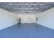 A clean garage featuring a painted gray floor, white brick walls, utility connections, and two entrances at 17236 Sw 44Th Cir, Ocala, FL 34473