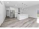 A modern, open kitchen features an island with pendant lighting, stainless appliances, and white cabinetry at 17236 Sw 44Th Cir, Ocala, FL 34473
