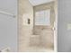 Updated shower stall with convenient seat and grab bar, decorative tile and shower head at 2007 Royal Bay Blvd # 144, Kissimmee, FL 34746