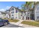 Inviting exterior of a two-story townhome featuring a quaint balcony and lush landscaping on a sunny day at 2007 Royal Bay Blvd # 144, Kissimmee, FL 34746