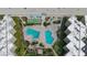Birds-eye view of pool area featuring two swimming pools, manicured landscaping and shuffleboard at 2401 S Atlantic Ave # D306, New Smyrna Beach, FL 32169