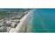 High aerial showing long beach, condo buildings, oceanfront location, and surrounding beachside community at 2401 S Atlantic Ave # D306, New Smyrna Beach, FL 32169