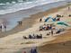 Busy beach with people sunbathing, swimming, and playing at 2401 S Atlantic Ave # D306, New Smyrna Beach, FL 32169