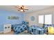 Bedroom with two twin beds, decorative wall art, and a ceiling fan at 2401 S Atlantic Ave # D306, New Smyrna Beach, FL 32169