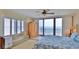 Bright bedroom featuring beachfront views from a private balcony and a decorative ceiling fan at 2401 S Atlantic Ave # D306, New Smyrna Beach, FL 32169