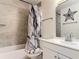 Bathroom showcasing neutral tiled walls, a shower, and a sink with an ornate mirror at 278 Silverstone Dr, Orange City, FL 32763