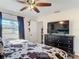 Comfortable main bedroom featuring a large window, dresser with television, and cowhide themed bedding at 278 Silverstone Dr, Orange City, FL 32763