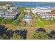 A wide aerial view of a stately clubhouse, pool, and the encompassing community, with a scenic lake beyond at 2827 Upper Park Road, Orlando, FL 32814