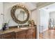 Stylish bathroom with a decorative mirror, granite countertops, and dark cabinets at 2827 Upper Park Road, Orlando, FL 32814