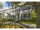 Elegant townhomes with classic design, black shutters, and beautifully maintained landscaping along a sidewalk at 2827 Upper Park Road, Orlando, FL 32814