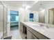 Modern bathroom with double vanity sinks, quartz countertops, and a glass-enclosed shower at 2861 Black Birch Dr, Ocoee, FL 34761