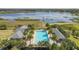 Aerial view of the community pool overlooking a lake, featuring palm trees and lounge chairs at 2861 Black Birch Dr, Ocoee, FL 34761