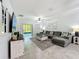 Bright living room featuring a comfortable sectional sofa, TV, and sliding glass doors at 2861 Black Birch Dr, Ocoee, FL 34761
