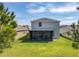 View of the home's back exterior showcasing the screened lanai and spacious, well-maintained backyard at 2861 Black Birch Dr, Ocoee, FL 34761
