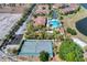 This aerial view showcases a community pool, tennis court, and meticulously landscaped surroundings with palm trees at 2898 Oakwater Dr # 2898, Kissimmee, FL 34747