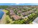 An aerial view displays orderly townhouses, manicured landscaping, and beautiful community waters at 2898 Oakwater Dr # 2898, Kissimmee, FL 34747