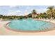 Beautiful community pool surrounded by lounge chairs and lush landscaping at 2898 Oakwater Dr # 2898, Kissimmee, FL 34747