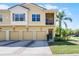 Inviting townhouse showcases a two-story elevation, four garage doors, and lush landscaping at 2898 Oakwater Dr # 2898, Kissimmee, FL 34747