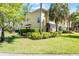 Inviting two-story townhome with lush green spaces, well-manicured shrubbery, and mature shade trees at 2898 Oakwater Dr # 2898, Kissimmee, FL 34747